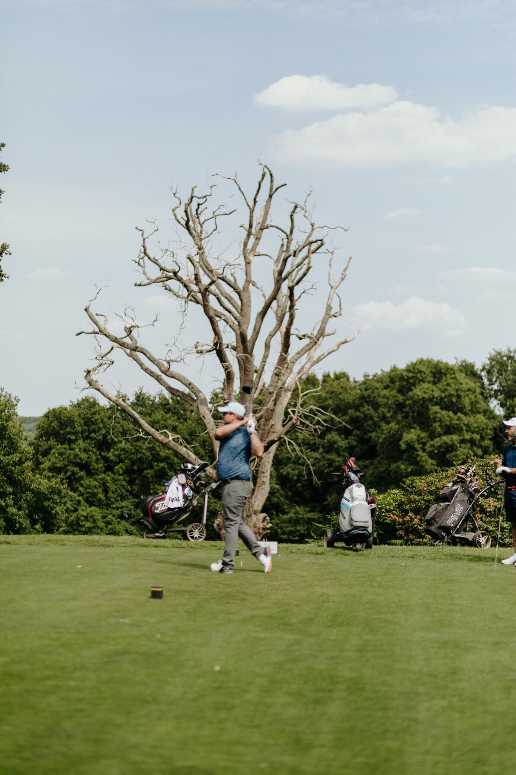 golf_pic20_swingwthtree_standing A man swinging a golfclub by a tree
