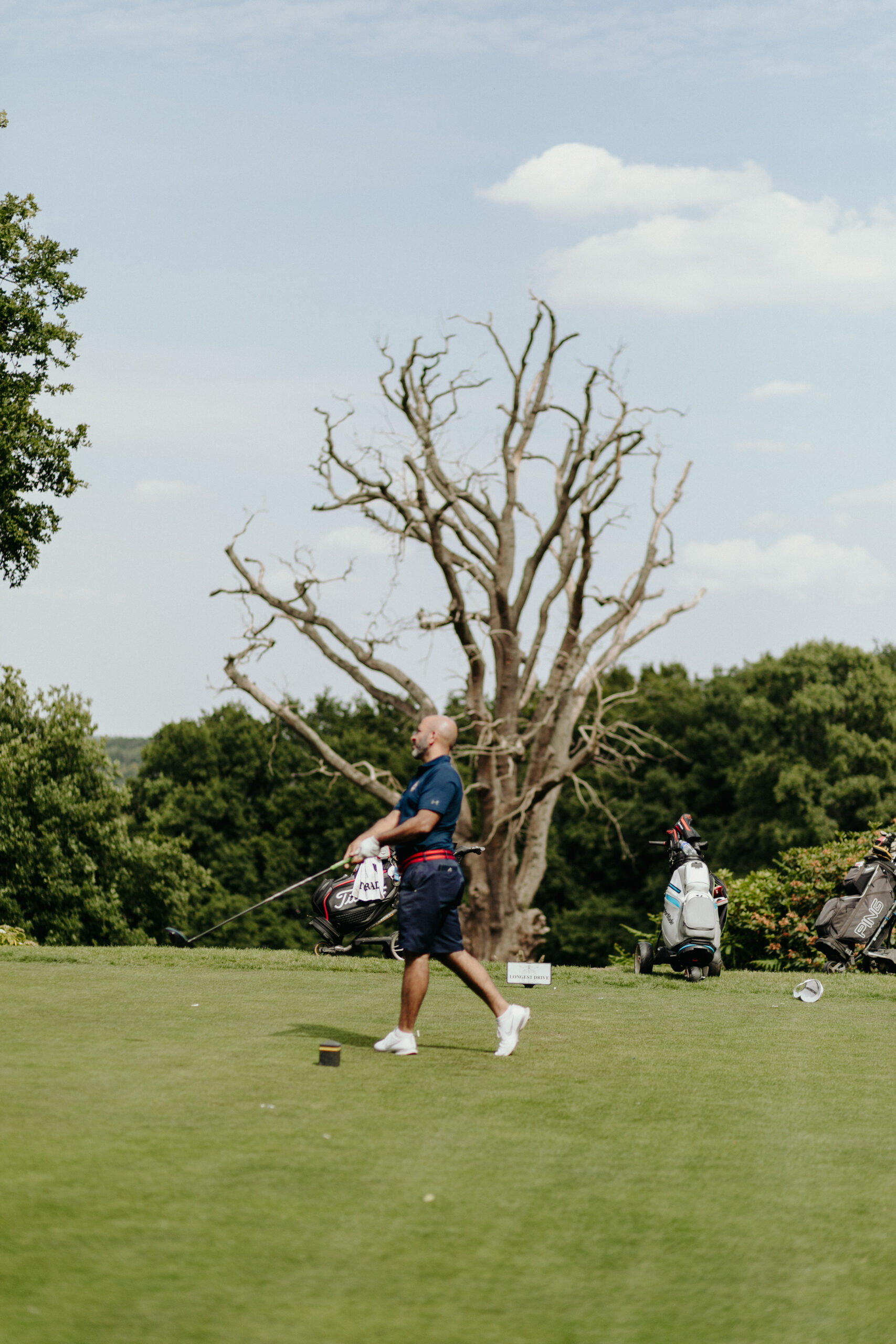 golf_pic21_swingwithtree_standing a man taking a golf swing by a tree