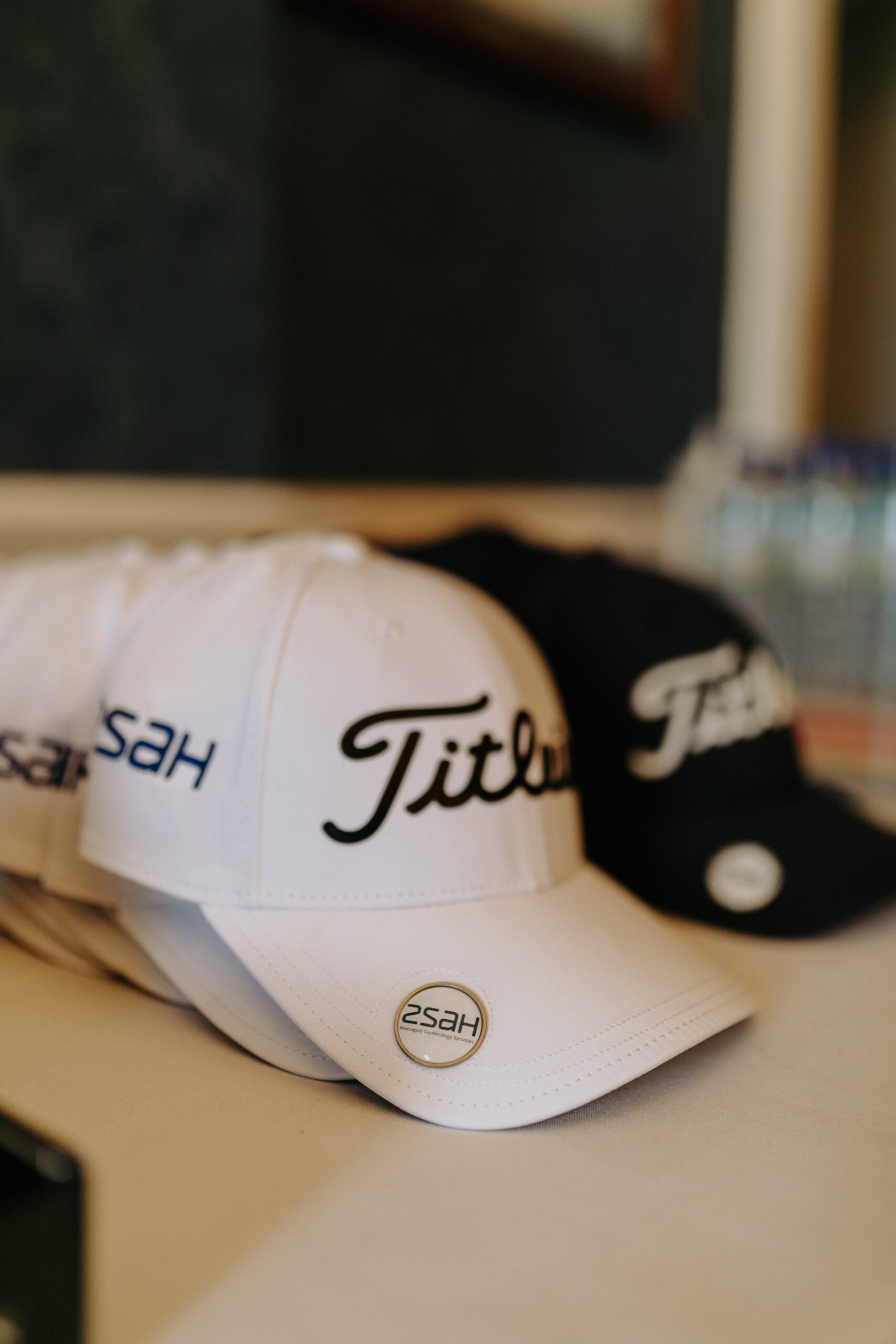 golf_pic6_titleist_standing close up of titleist caps in white and navy laying on a table